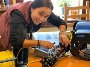 A person works on wires inside a remotely operated vehicle (ROV).